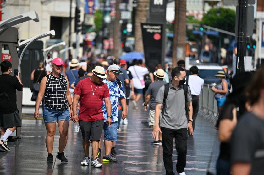 Tourists walk on Hollywood Boulevard's Walk of Fame, August 16, 2021 in Hollywood, California. - Tourism on Hollywood Boulevards has increased as much as 153% between April and June after a severe drop off during the early part of the Covid-19 pandemic, according to a report published in the Los Angeles Times on August 16, 2021. Business owners say theyre seeing a larger proportion of visitors from the U.S. over international tourists. (Photo by Robyn Beck / AFP) (Photo by ROBYN BECK/AFP via Getty Images)