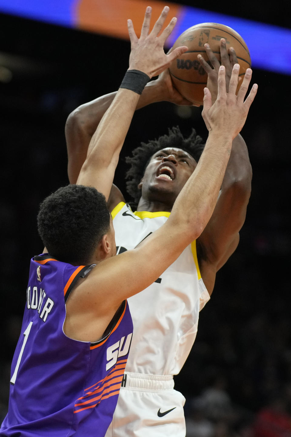 Utah Jazz guard Collin Sexton shoots over Phoenix Suns guard Devin Booker (1) during the first half of an NBA basketball game, Saturday, Nov. 26, 2022, in Phoenix. (AP Photo/Rick Scuteri)