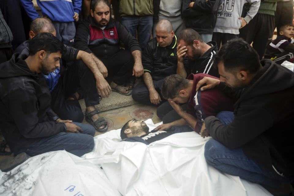 Palestinians mourn relatives killed in the Israeli bombardment of the Gaza Strip outside a morgue in Khan Younis on Friday, Dec. 15, 2023. (AP Photo/Mohammed Dahman)