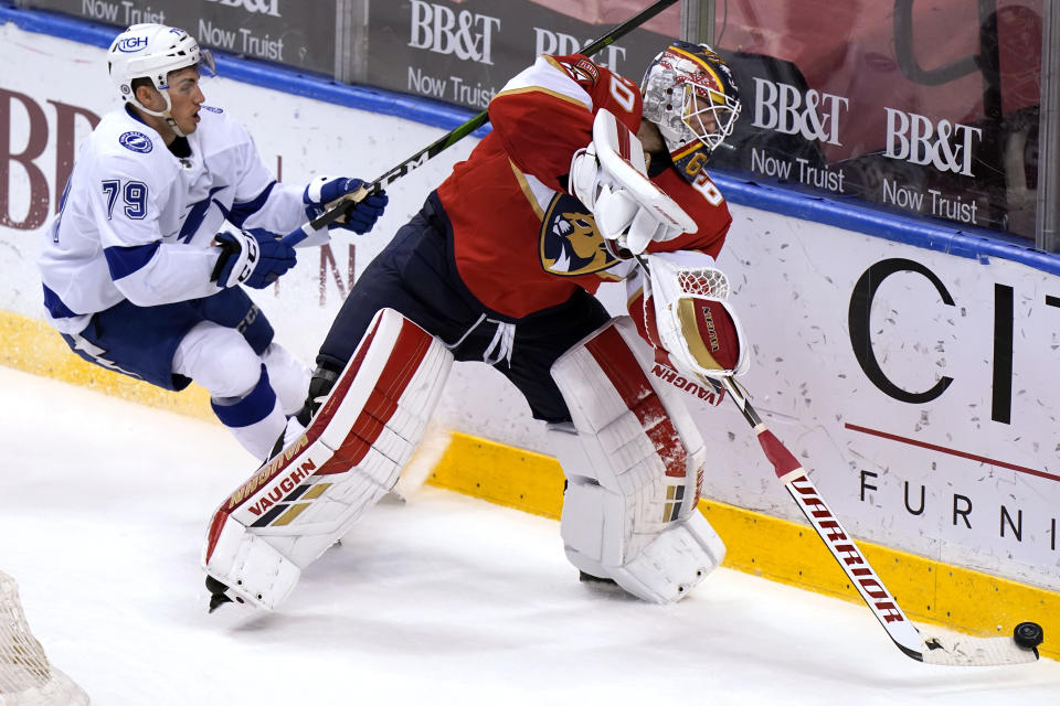 Florida Panthers goaltender Chris Driedger, right, clears the puck from behind the goal as Tampa Bay Lightning left wing Ross Colton, left, defends during the third period of an NHL hockey game, Monday, May 10, 2021, in Sunrise, Fla. (AP Photo/Lynne Sladky)