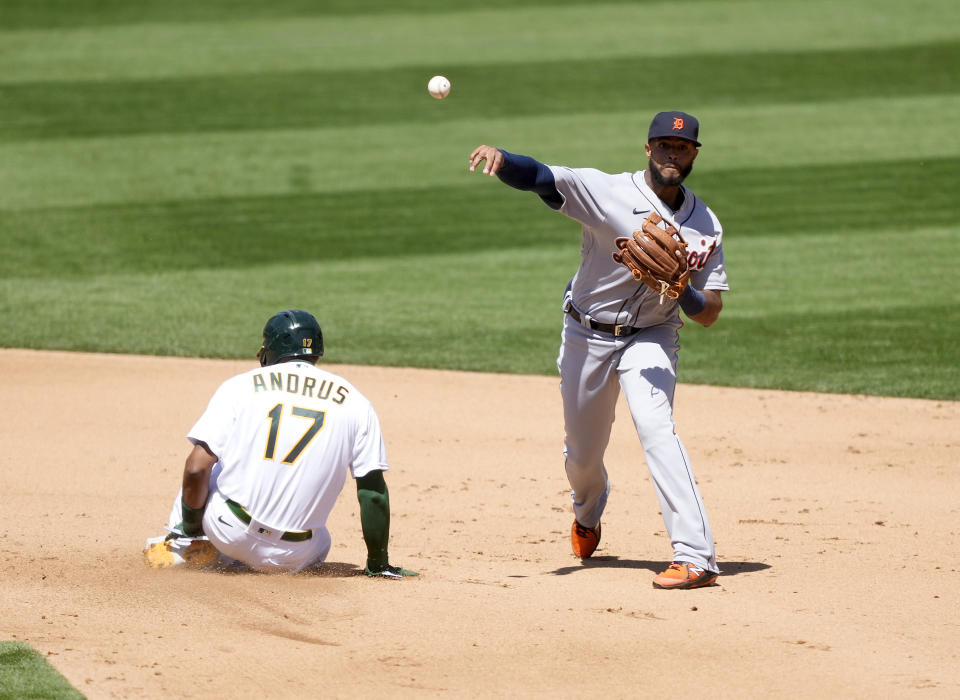 Detroit Tigers shortstop Willi Castro, right, throws to first base after forcing out Oakland Athletics' Elvis Andrus (17) at second base during the fourth inning of a baseball game on Saturday, April 17, 2021, in Oakland, Calif. (AP Photo/Tony Avelar)