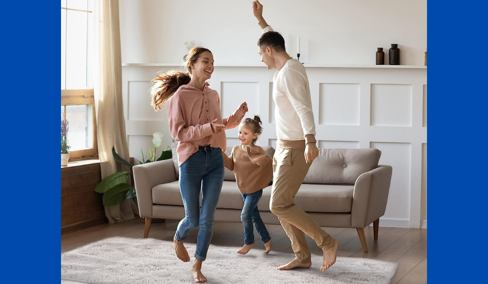 family dancing on a rug that's staying in place with rug grippers