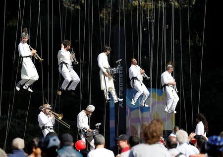 Lifted musicians perform as the Olympic torch is relayed along Paulista Avenue in Sao Paulo's financial center, Brazil, July 24, 2016. REUTERS/Paulo Whitaker