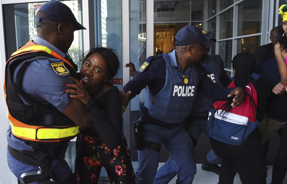 Protesters break through a police cordon to gain entry where the World Economic Forum on Africa is being held in Cape Town, South Africa, Wednesday, Sept. 4, 2019. The women are demanding that the government crack down on gender-based violence, following a week of brutal murders of young South African women that has shaken the nation. (AP Photo)