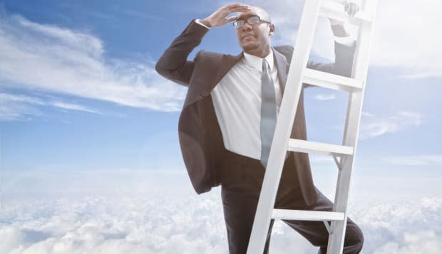 African American businessman climbing ladder