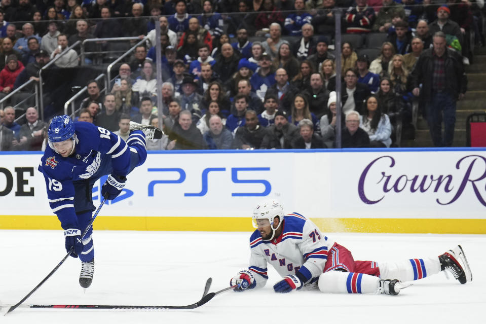 Toronto Maple Leafs forward Calle Jarnkrok (19) trips as New York Rangers defenseman K'Andre Miller (79) defends during the second period of an NHL hockey game Tuesday, Dec. 19, 2023, in Toronto. (Nathan Denette/The Canadian Press via AP)