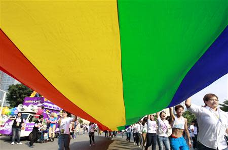 Participants hold a giant rainbow flag during the Taiwan LGBT Pride Parade in Taipei October 26, 2013. REUTERS/Pichi Chuang