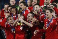 Germany's Bayern Munich Franck Ribery (2nd R) and Philipp Lahm hold the trophy as they celebrate with their team mates after winning their 2013 FIFA Club World Cup soccer match against Morocco's Raja Casablanca at Marrakech stadium December 21, 2013. REUTERS/Youssef Boudlal