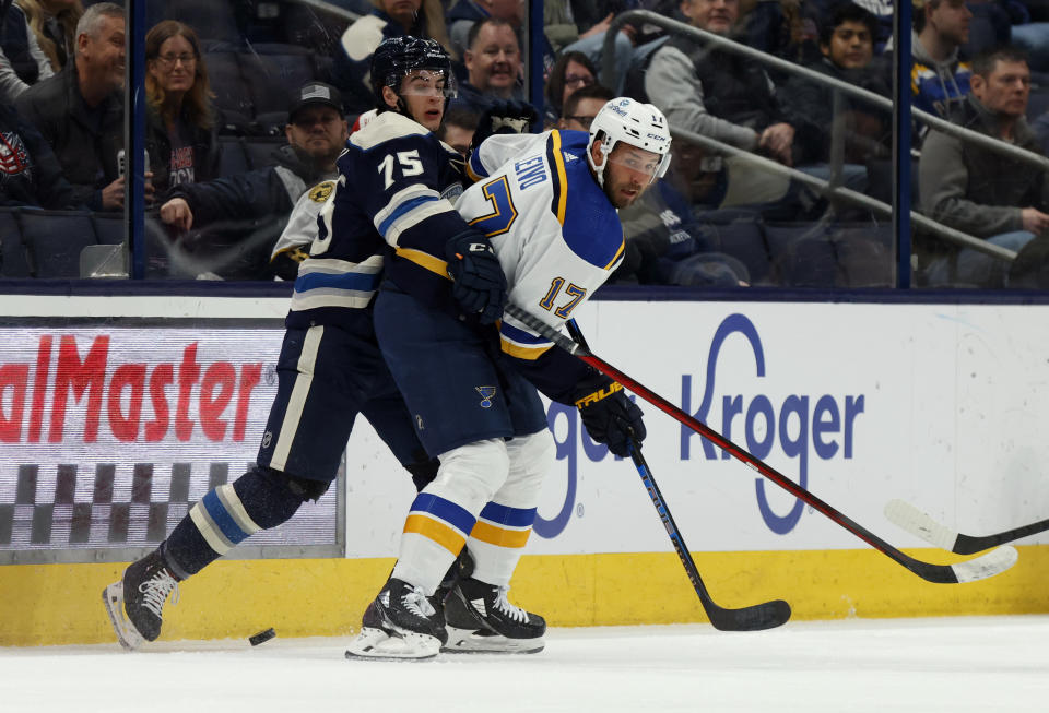 Columbus Blue Jackets defenseman Tim Berni, left, works for the puck behind St. Louis Blues forward Josh Leivo during the first period of an NHL hockey game in Columbus, Ohio, Saturday, March 11, 2023. (AP Photo/Paul Vernon)