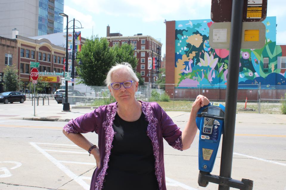Margee Miller, a contributor to "The Parking Spaces" audio installation, poses for a portrait Tuesday outside of space seven, the Iowa City Senior Center.