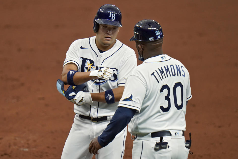 Tampa Bay Rays' Yoshi Tsutsugo, of Japan, celebrates his single off New York Yankees starting pitcher Corey Kluber with first base coach Ozzie Timmons (30) during the third inning of a baseball game Friday, April 9, 2021, in St. Petersburg, Fla. (AP Photo/Chris O'Meara)