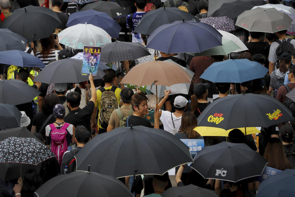 People carry umbrellas during an anti-extradition bill protest march in Hong Kong, Sunday, Aug. 4, 2019. Hong Kong police said Sunday that they arrested more than 20 people for unlawful assembly, assault and other offenses after confrontations between protesters and authorities continued deep into the night. (AP Photo/Vincent Thian)