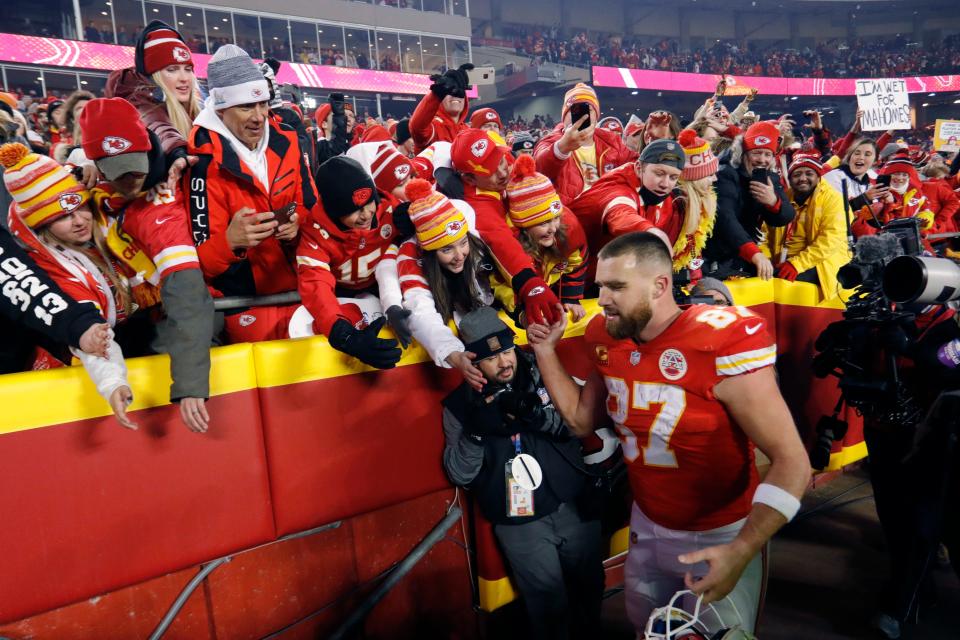 Kansas City Chiefs tight end Travis Kelce celebrates with fans as he walks off the field after an NFL divisional round playoff football game against the Buffalo Bills, Sunday, Jan. 23, 2022. Attention on him is now at an all-time high because of his relationship with Pop superstar Taylor Swift.