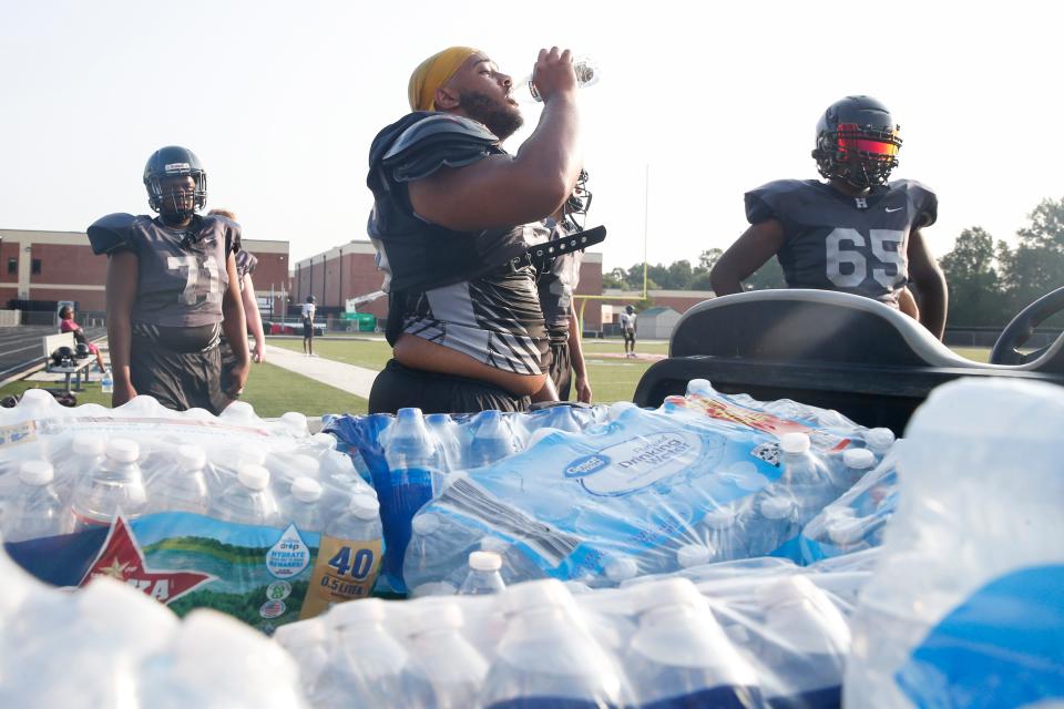 Houston football players take a water break during practice at Houston High School in Germantown, Tenn., on Monday, July 24, 2023. Players were drinking out of water bottles as Germantown residents continued to be advised not to drink the city’s tap water after it was discovered on Thursday that a generator was leaking diesel fuel into an underground reservoir.