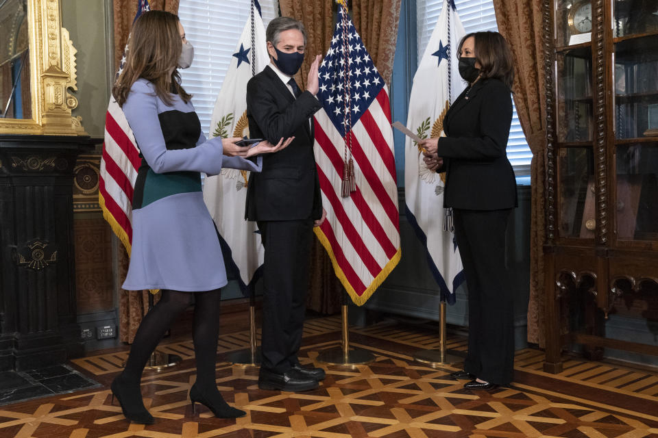 Antony Blinken, center, takes his place to be ceremonially sworn-in by Vice President Kamala Harris, right, before being reminded by his wife Evan Ryan to stand further back, Wednesday, Jan. 27, 2021, in Harris' ceremonial office in the Eisenhower Executive Office Building on the White House complex in Washington. (AP Photo/Jacquelyn Martin)