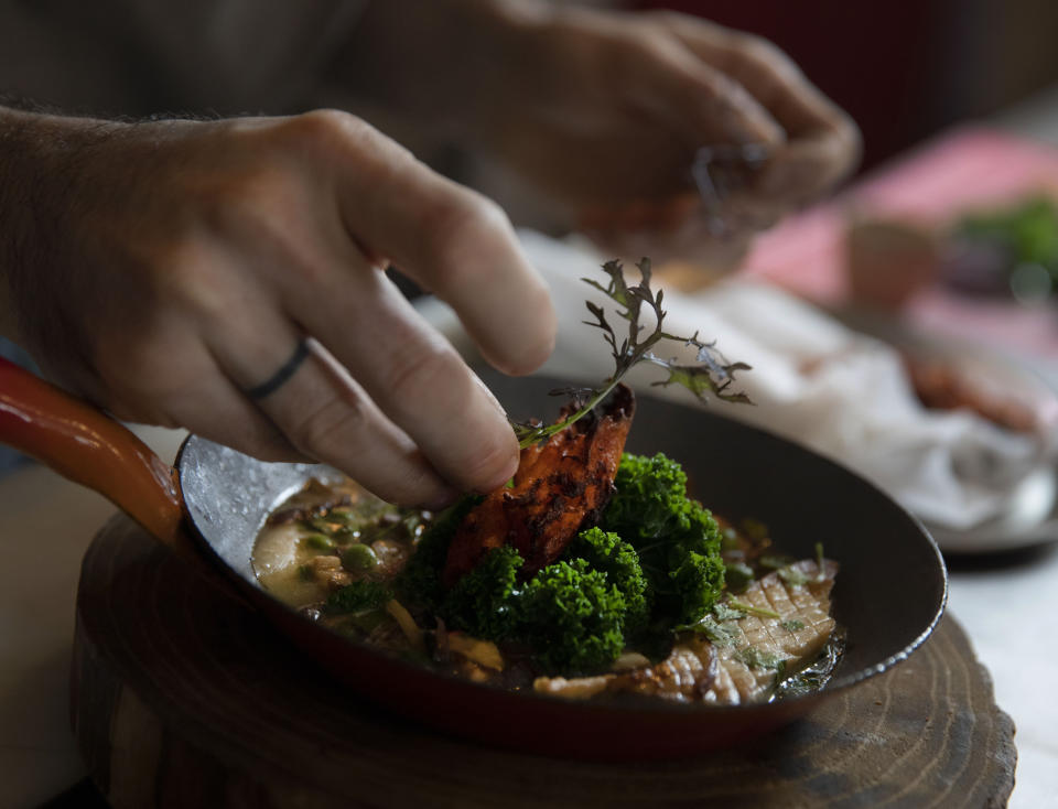 Chef Benjamin Gaugue, creates a dish combining different varieties of mushrooms and microgreens from Le Champignon de Bruxelles at his restaurant, De Bruxelles et D'ailleurs, in Brussels, Friday, Feb. 14, 2020. Gaugue is not only seduced by the savory greens, he also sees the ecological side of a project which implements a form of circular economy in an urban context. (AP Photo/Virginia Mayo)