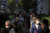 People wearing face masks, line up to receive China's Sinovac COVID-19 coronavirus vaccine at a community vaccination center in Hong Kong, Monday, Nov. 29, 2021. The emergence of the new omicron variant and the world’s desperate and likely futile attempts to keep it at bay are reminders of what scientists have warned for months: The coronavirus will thrive as long as vast parts of the world lack vaccines. (AP Photo/Kin Cheung)