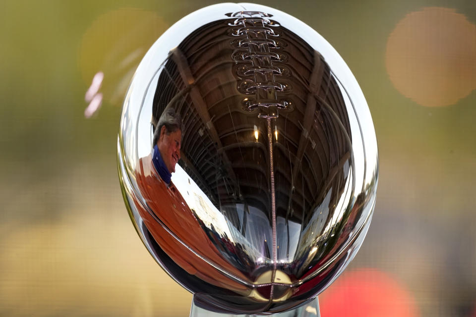 A man looks at the Lombardi Trophy at the NFL Experience Thursday, Feb. 4, 2021, in Tampa, Fla. The city is hosting Sunday's Super Bowl football game between the Tampa Bay Buccaneers and the Kansas City Chiefs. (AP Photo/Charlie Riedel)