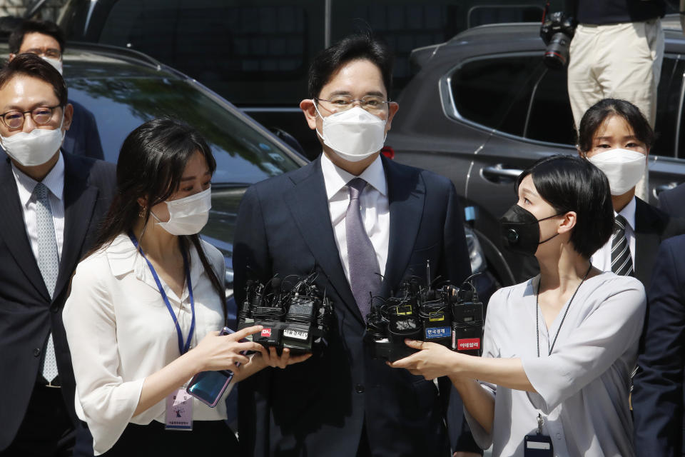 FILE - In this June. 8, 2020, file photo, Samsung Electronics Vice Chairman Lee Jae-yong, center, arrives at the Seoul Central District Court in Seoul, South Korea. Pressure is mounting on South Korean President Moon Jae-in to pardon Samsung heir Lee Jae-yong, who is back in prison after his conviction in a massive corruption scandal, even though business has rarely looked better at South Korea’s largest company. (AP Photo/Ahn Young-joon, File)