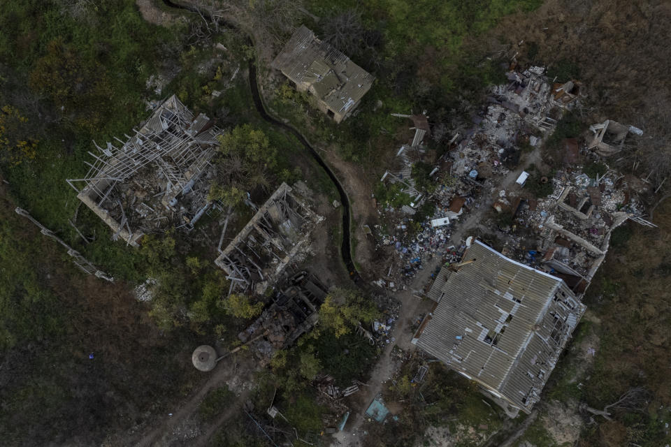 A view of a Russian tank and destroyed buildings of a recently liberated village on the outskirts of Kherson, in southern Ukraine, Wednesday, Nov. 16, 2022. (AP Photo/Bernat Armangue)