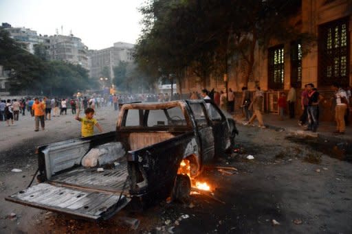 A burnt pick-up truck is seen during clashes between Egyptian protesters and riot police near the US embassy in Cairo on September 13. The US has boosted security at its embassies amid fears that more anti-American violence sparked by a film mocking Islam could erupt after Friday's Muslim prayers across the Middle East and North Africa