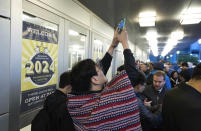 Daegwon Kim of South Korea, who arrived in line at 3:30 a.m., takes photos of the crowd behind him outside the Berkshire Hathaway annual meeting on Saturday, May 4, 2024, in Omaha, Neb. (AP Photo/Rebecca S. Gratz)