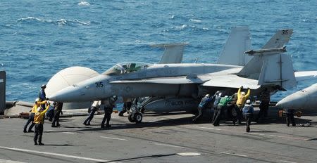 Sailors guide an F/A-18C Hornet assigned to the Valions of Strike Fighter Squadron (VFA) 15 on the flight deck of the aircraft carrier USS George H.W. Bush (CVN 77) in the Gulf, in this handout image taken and released on August 8, 2014. REUTERS/Mass Communication Specialist 3rd Class Lorelei Vander Griend/U.S. Navy/Handout via Reuters