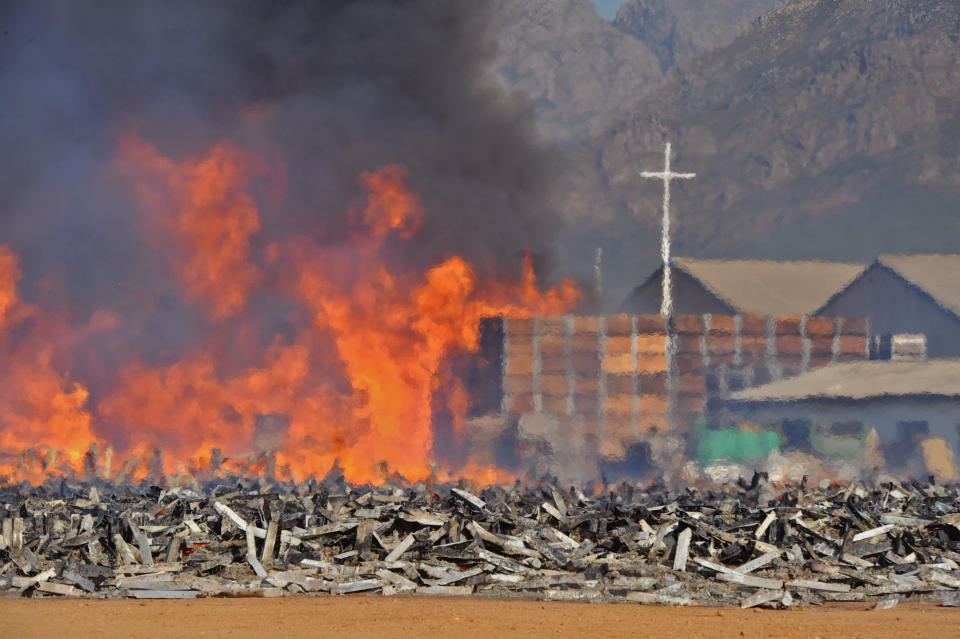 The remainder of 18,000 empty fruit containers after they were set alight by farm workers in Wolseley, South Africa, Wednesday, Nov. 14, 2012. Violent protests by farm workers have erupted in South Africa after weeks of unrest in the country's mining industry. Television images showed protesters overturn a police truck and set fires in the streets Wednesday in a town in South Africa's Western Cape. The workers have been protesting their wages, saying they want a minimum wage of $17 a day. Currently, workers make about half that amount a day. (AP Photo)