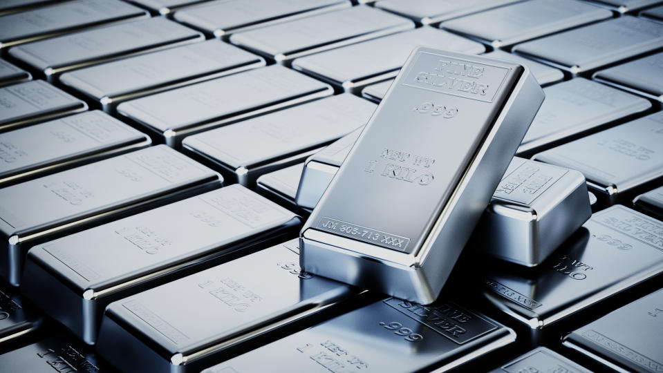 Multiple one-kilo silver bars are neatly arranged, showing off their luster and texture, reflecting wealth, stability and investment in precious metals.  The stamped inscriptions indicate purity and weight and emphasize the bars as a form of tangible possession.