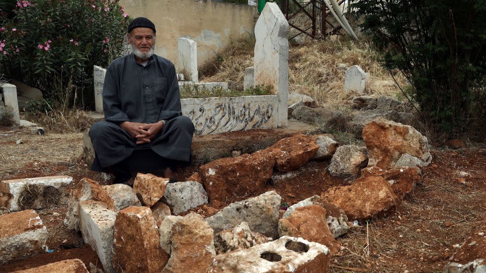 Mohammad Mesto sits next to the grave of his brother Lutfi, who was killed on May 3 in a suspected US military strike in northern Syria. - Omar Albam/AP