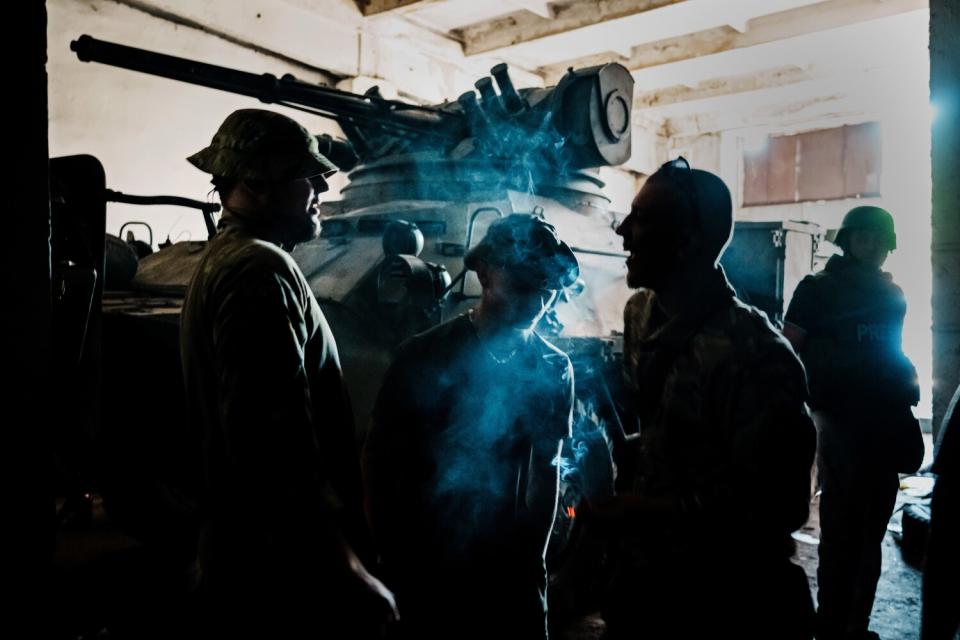 A crew stands ready with a heavy armored vehicle