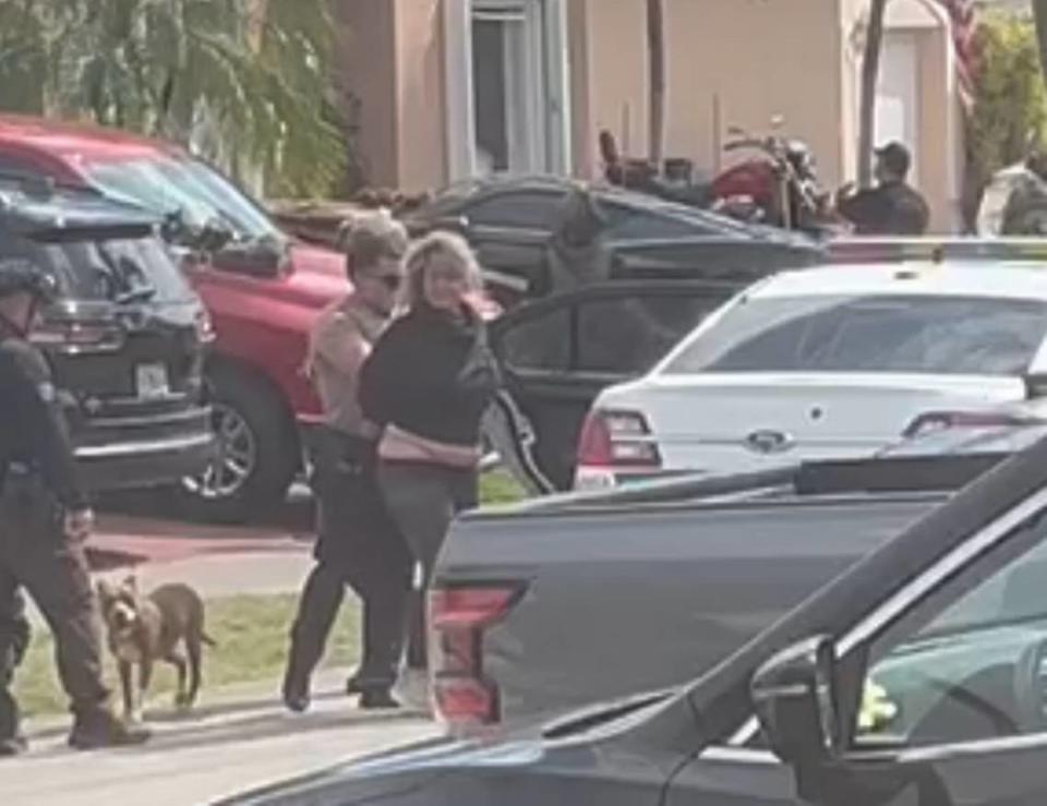 Miami-Dade Police officers walk a handcuffed Evelyn Fernandez to a patrol car after arresting her Friday, Oct. 27, 2023, following an armed standoff that lasted more than 12 hours.