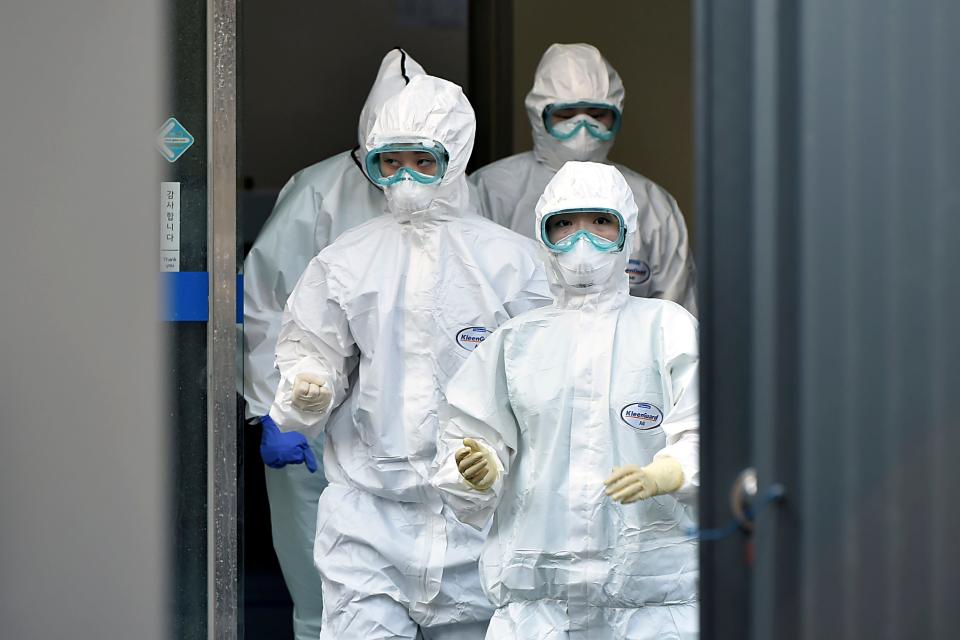 Medical staff members arrive for a duty shift at Dongsan Hospital in Daegu, South Korea, Wednesday, March 18, 2020. For most people, the new coronavirus causes only mild or moderate symptoms, such as fever and cough. For some, especially older adults and people with existing health problems, it can cause more severe illness, including pneumonia. (Lee Moo-ryul/Newsis via AP) ORG XMIT: SEL801