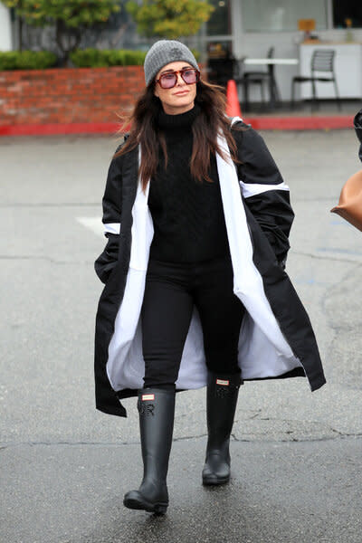 Kyle Richards wearing a grey beanie and long coat while walking.