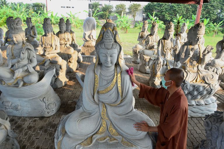 Un sacerdote budista limpia las estatuas de Buda en el templo Vihara Mahavira en Semarang