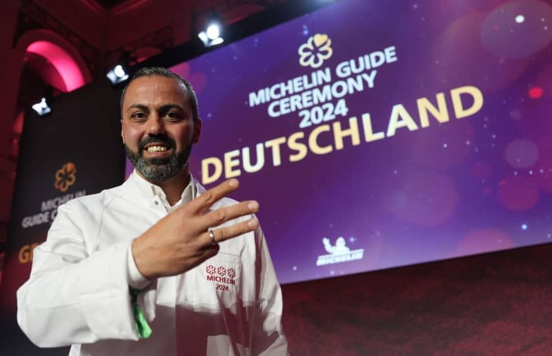 Three-star chef Edip Sigl from the "Ess:enz" restaurant in Grassau takes to the stage at the Chamber of Commerce after receiving the 2024 Michelin stars for German restaurants. Marcus Brandt/dpa