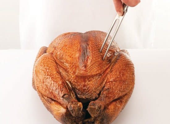 Place the turkey on the cutting board or a platter, breast side up, with the legs facing away from you. Steady it with the carving fork in your guide hand.