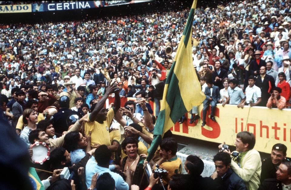 Pelé sostiene en alto el trofeo de la Copa del Mundo —el tercero suyo y de Brasil— en 1970 (Popperfoto/Getty)