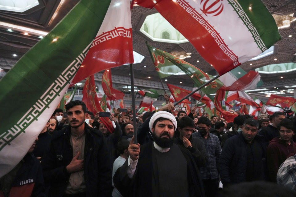 Mourners wave Iranian and Islamic flags during a ceremony marking anniversary of the death of the late Revolutionary Guard Gen. Qassem Soleimani, who was killed in Iraq in a U.S. drone attack in 2020, at Imam Khomeini Grand Mosque in Tehran, Iran, Tuesday, Jan. 3, 2023. Iran's President Ebrahim Raisi on Tuesday vowed to avenge the killing of the country's top general on the third anniversary of his death, as the government rallied its supporters in mourning amid months of anti-government protests. (AP Photo/Vahid Salemi)