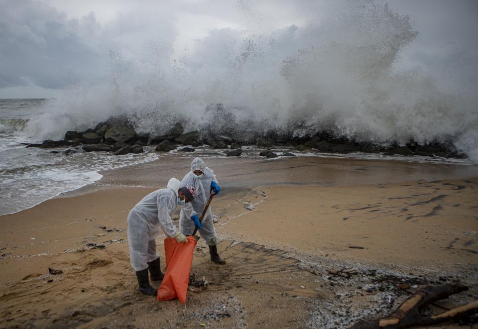 Sri Lankan navy soldiers clean the plastic debris washed ashore from fire damaged container ship MV X-Press Pearl at Kapungoda, on the outskirts of Colombo, Sri Lanka. Monday, June 14, 2021. (AP Photo/Eranga Jayawardena)