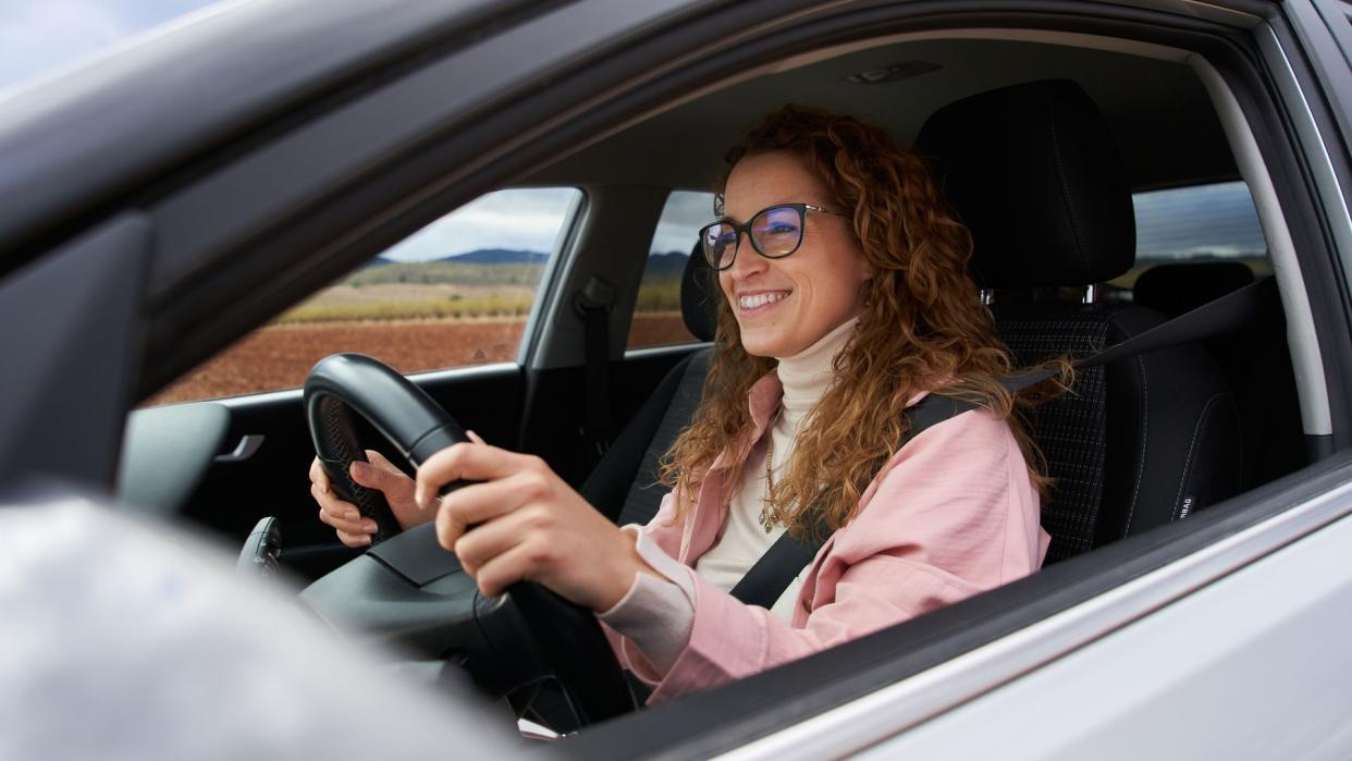 Happy portrait of a woman inside her new car 