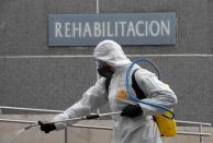 A member of the Military Emergency Unit (UME) sprays disinfectant to prevent the spread of the coronavirus disease (COVID-19) at Cabuenes Hospital in Gijon