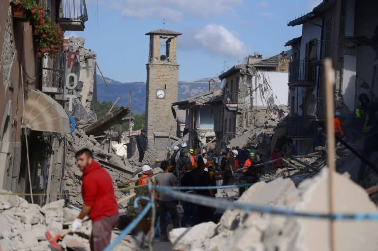 Rescuers and firemen search the rubble of buildings in Amatrice, central Italy on August 24, 2016 following the earthquake that struck before dawn