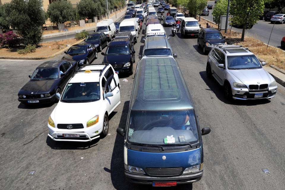 Lines of cars and mini buses wait in a long queue for gasoline, in Beirut, Lebanon, Friday, June 25, 2021. Lebanon's caretaker prime minister on Friday granted his approval to allow the financing of fuel imports at a rate higher than the official exchange rate, effectively reducing critical fuel subsidies that have been in place for decades, amid worsening gasoline shortages. (AP Photo/Hussein Malla)