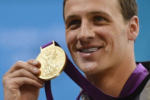 US swimmer Ryan Lochte poses on the podium with the gold medal after winning the men's 400m individual medley swimming event at the London 2012 Olympic Games in London