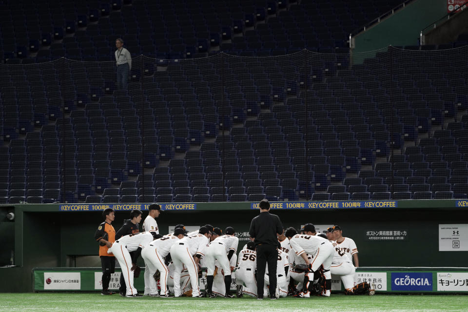 Spectators' stands are empty during a warm up session in a preseason baseball game between the Yomiuri Giants and the Yakult Swallows at Tokyo Dome in Tokyo Saturday, Feb. 29, 2020. Japan's professional baseball league said Thursday it will play its 72 remaining preseason games in empty stadiums because of the threat of the spreading coronavirus.(AP Photo/Eugene Hoshiko)