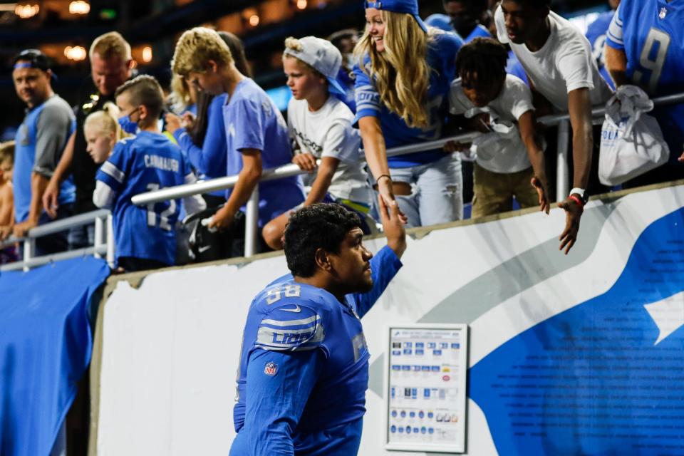 Detroit Lions offensive tackle Penei Sewell (58) high fives fans after the Lions lost 27-17 to the Indianapolis Colts in a preseason game at Ford Field in Detroit on Friday, Aug. 27, 2021.