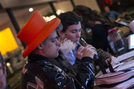 Customers puff on e-cigarettes at the Henley Vaporium in New York City December 18, 2013. REUTERS/Mike Segar