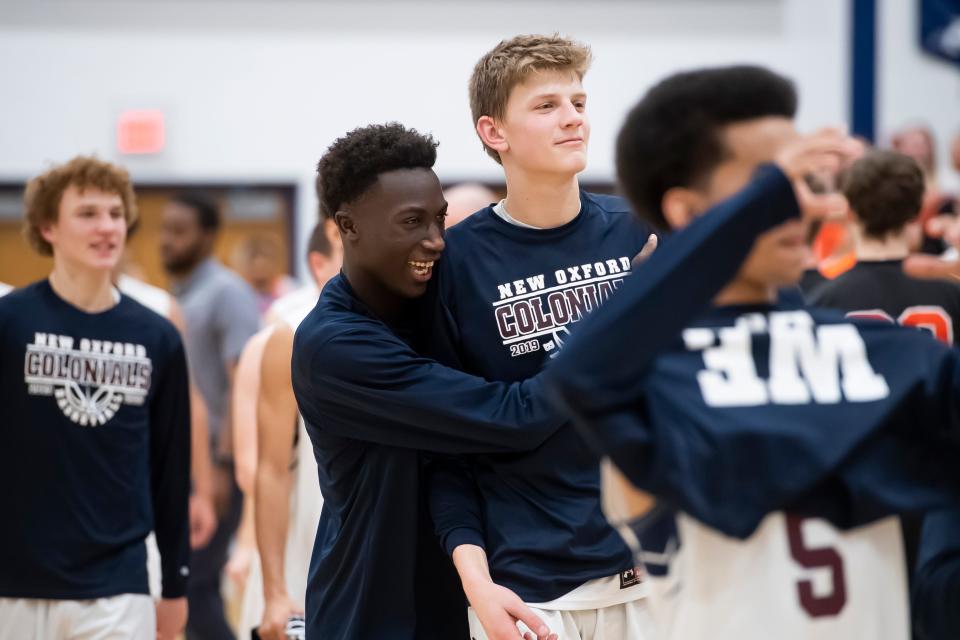 Abdul Janneh (left) and Tommy Haugh celebrate following the Colonials' 69-41 win over Hanover in a YAIAA tournament quarterfinal game on Friday, Feb. 7, 2020.