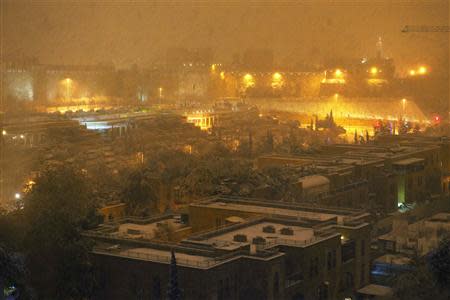 Snow falls at night over Jerusalem December 12, 2013. REUTERS/Brian Snyder